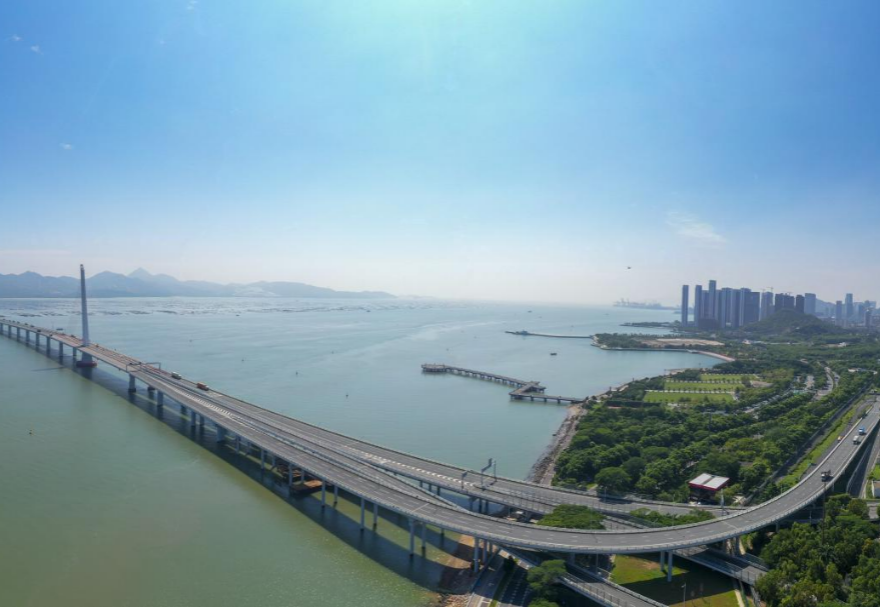 深圳灣大橋是繼羅湖、皇崗和沙頭角之后深圳第4條跨境通道，全長5545米，設南北兩個通航橋，主跨分別為210米和180米。大橋連接深圳蛇口與香港元朗，為中國公路干線網(wǎng)中唯一與香港連接的高速公路大橋，也是廣深沿江高速公路的咽喉。廣州與香港的距離因該橋建成通車縮短至100千米。大橋深圳側獨塔斜拉橋塔采用向香港側傾斜的斜塔，與香港側斜拉橋的橋塔向深圳側傾斜互相對應，寓意深港兩地手牽手走向一起。圖為深圳灣大橋。