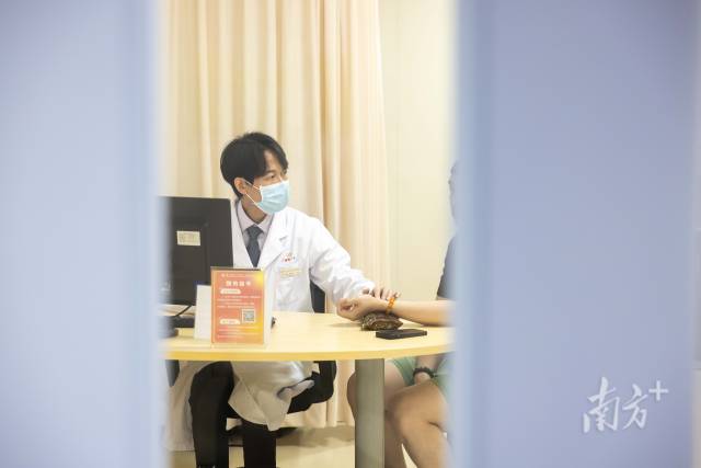 梁偉衡在給病人看診。
