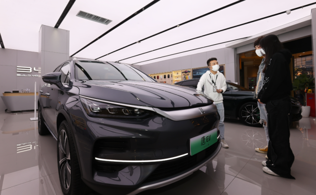 比亞迪店內(nèi)，一名銷售人員（左）正在向兩位顧客介紹車輛信息。深圳特區(qū)報(bào)記者 楊浩翰 攝