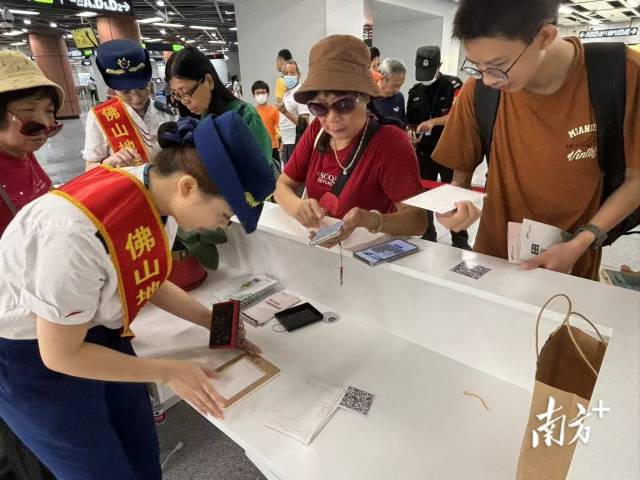 市民在桂城站便民服務(wù)臺用明信片蓋章打卡。龍西男 攝