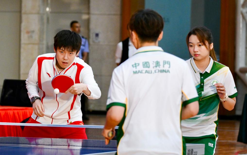 9月1日，乒乓球運(yùn)動(dòng)員王楚欽（左）與澳門(mén)運(yùn)動(dòng)員切磋球技。當(dāng)日，內(nèi)地奧運(yùn)健兒代表團(tuán)在澳門(mén)奧林匹克體育中心室內(nèi)體育館與澳門(mén)青少年運(yùn)動(dòng)員進(jìn)行互動(dòng)交流。新華社記者 郭雨祺 攝