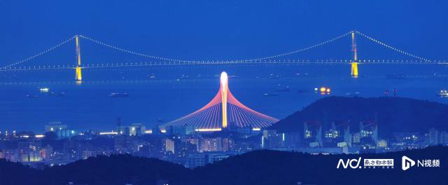 夜幕下，東莞濱海灣大橋與遠(yuǎn)處的深中通道亮起標(biāo)志性的燈光。