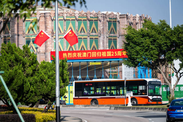12月17日，車輛從慶祝澳門回歸祖國25周年橫幅旁駛過。新華社記者 朱煒 攝