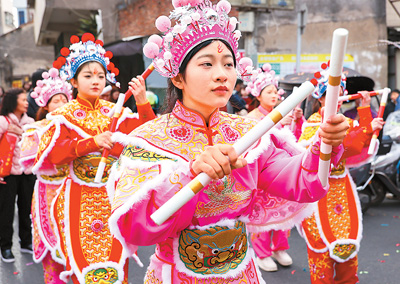  春節(jié)期間，英歌舞隊(duì)員在廣東省汕頭市潮陽區(qū)海門鎮(zhèn)街頭巡游表演。王文攝（人民視覺）
