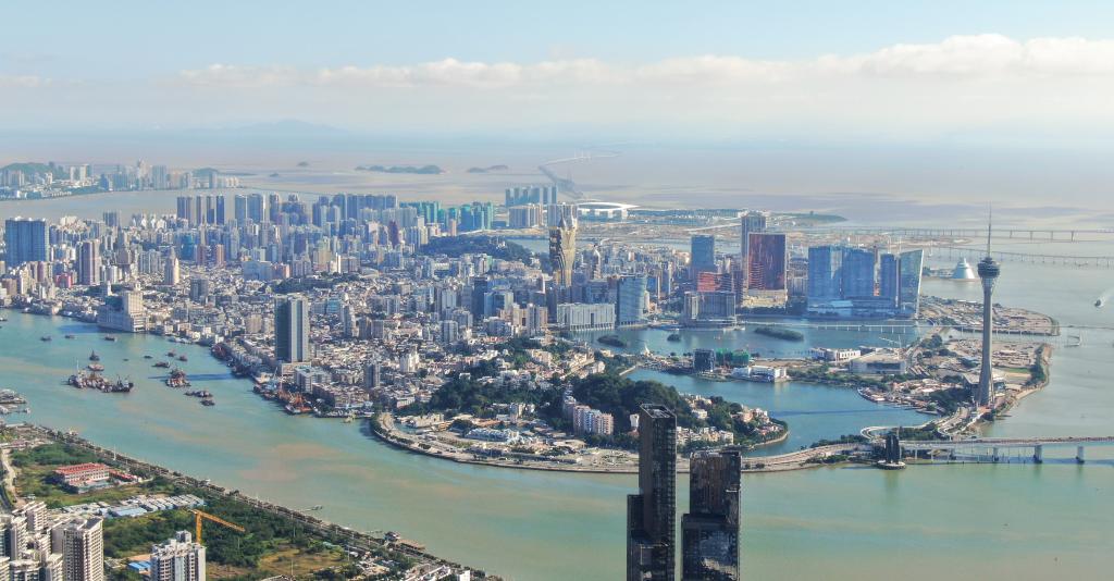 從珠海市區(qū)拍攝的澳門及遠處的港珠澳大橋（2024年11月26日攝，無人機照片）。新華社記者 鄧華 攝