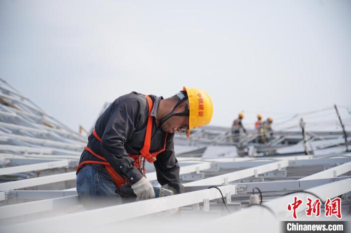 建設(shè)者們忙于幕墻工程、金屬屋面、機電安裝、精裝修施工。記者 韋杰夫 攝