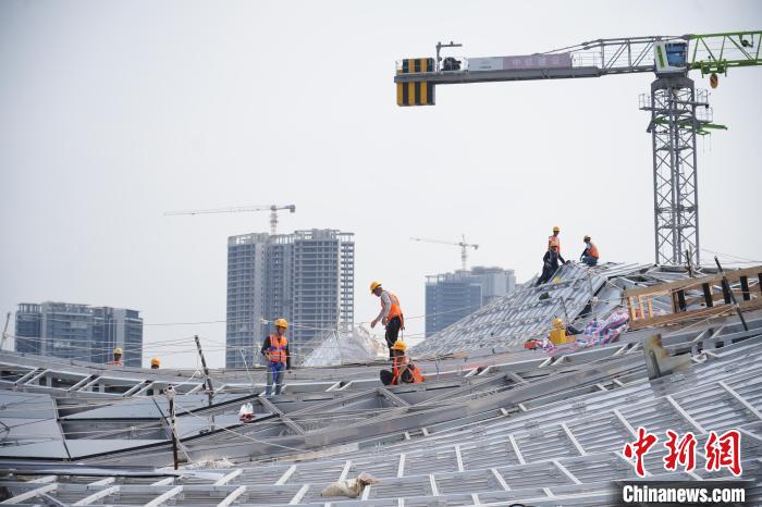 建設(shè)者們忙于幕墻工程、金屬屋面、機電安裝、精裝修施工。記者 韋杰夫 攝