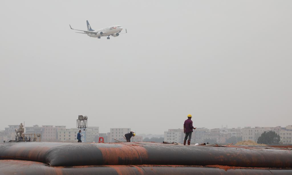 2025年1月23日，一架準(zhǔn)備降落的飛機(jī)經(jīng)過(guò)白云機(jī)場(chǎng)擴(kuò)建工程施工現(xiàn)場(chǎng)。新華社記者 田建川 攝